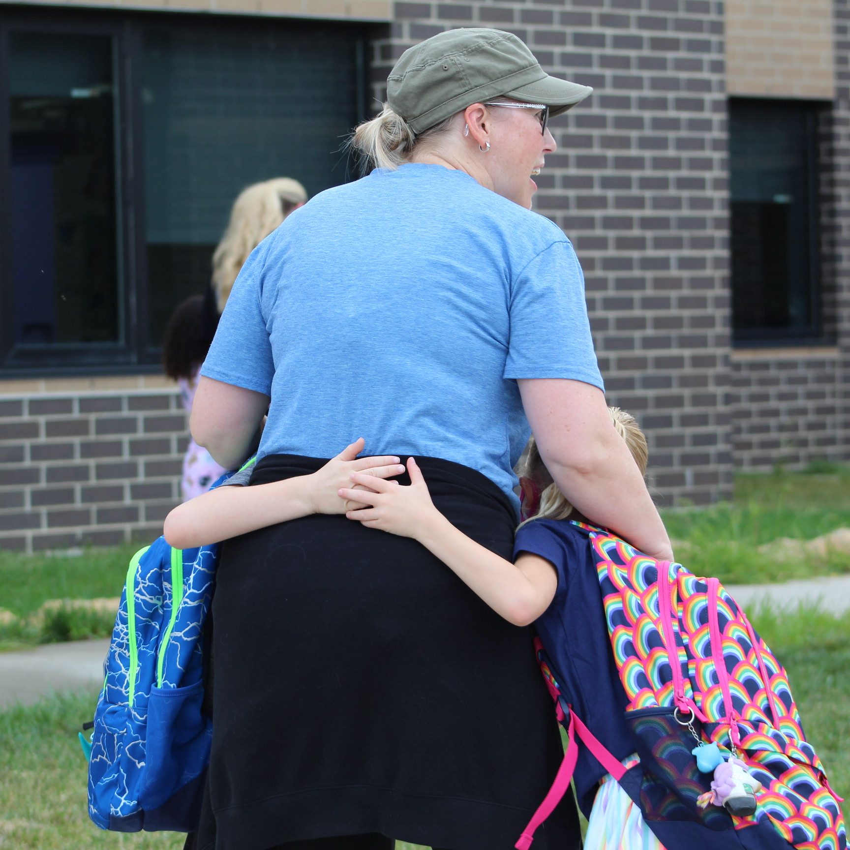 woman hugging children