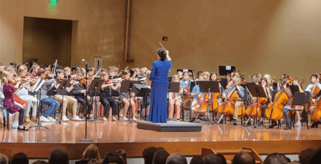 Teacher conducting orchestra students