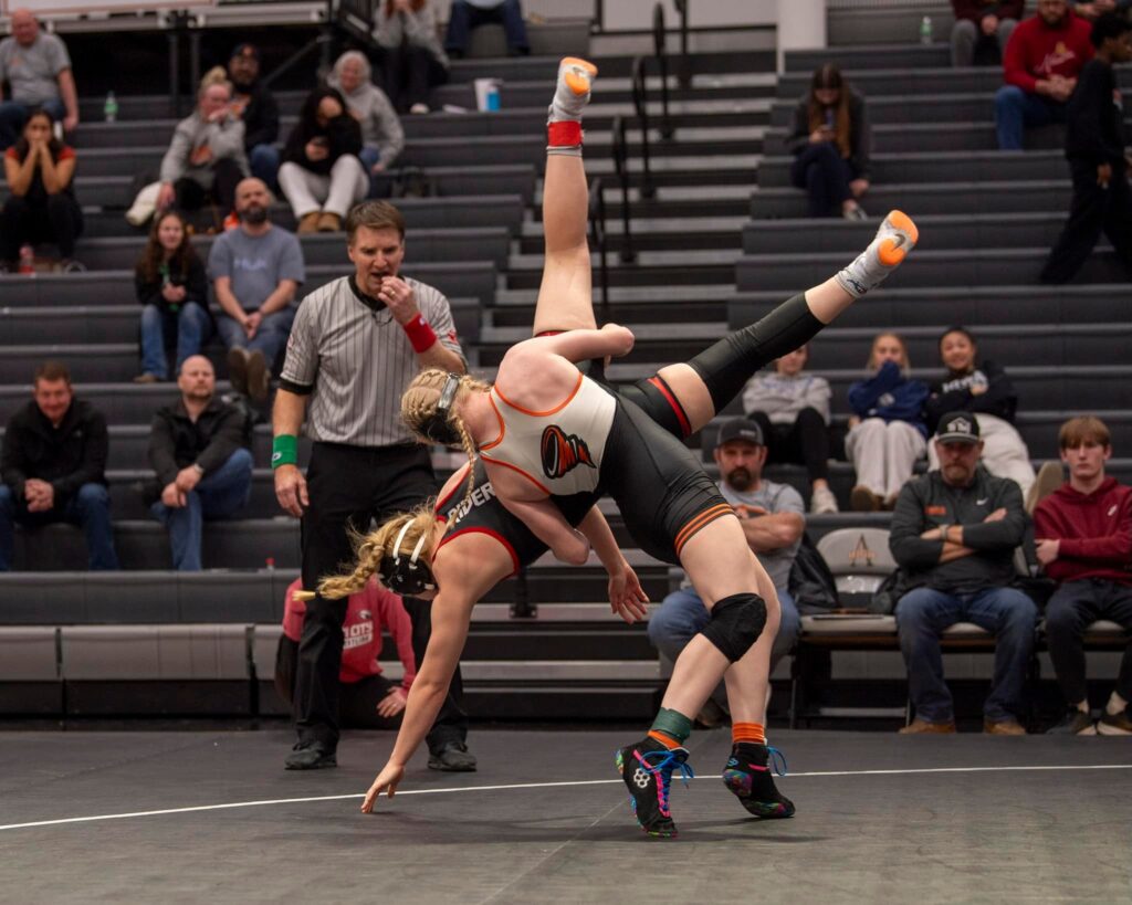 wrestler taking another wrestler down to the mat